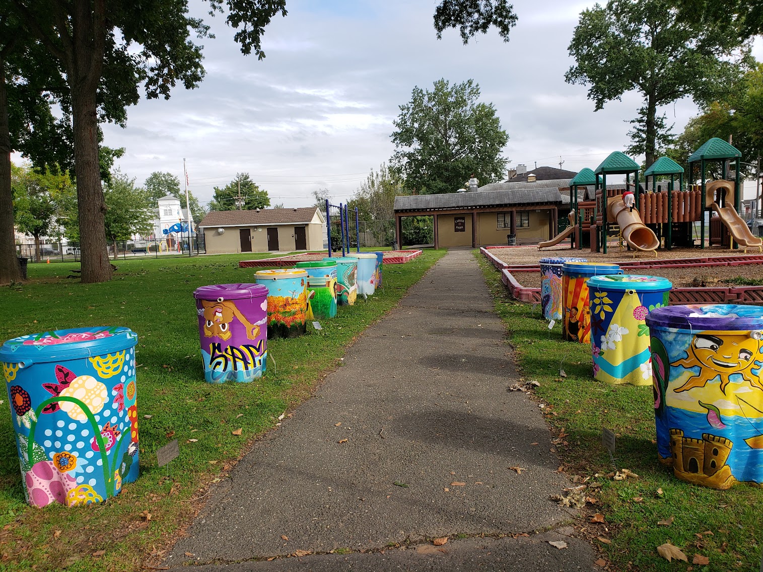 Painted rain barrels beautify a park and provide an example of a strategy to mitigate flooding.